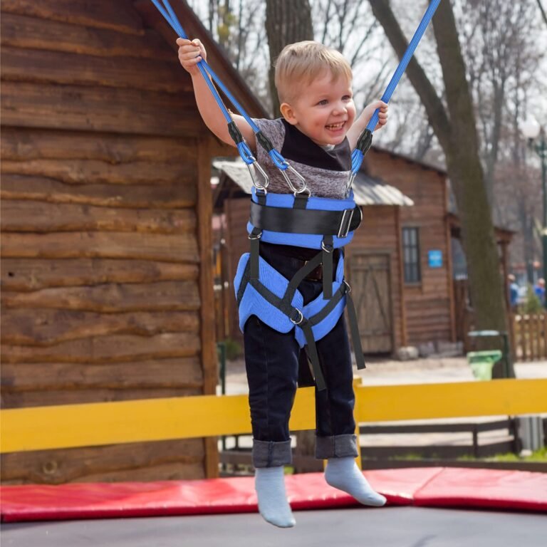 Smiling child jumping on a trampoline with a bungee harness